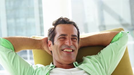 Smiling-man-relaxing-on-sofa-at-home