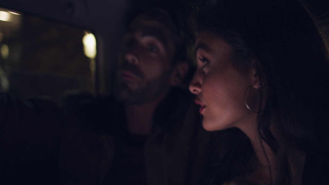 밤 에 자동차 에서 전화 를 보고 있는 부부