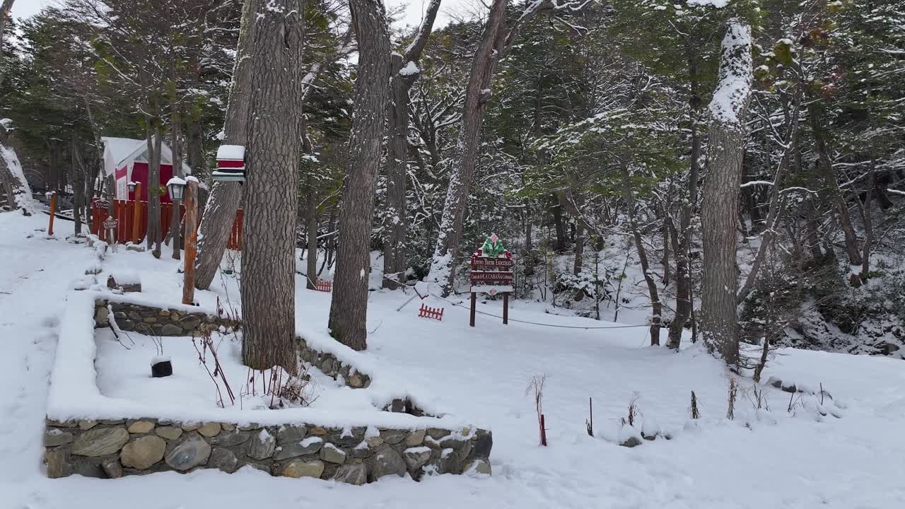 Snowy path leading through a winter forest with a sign