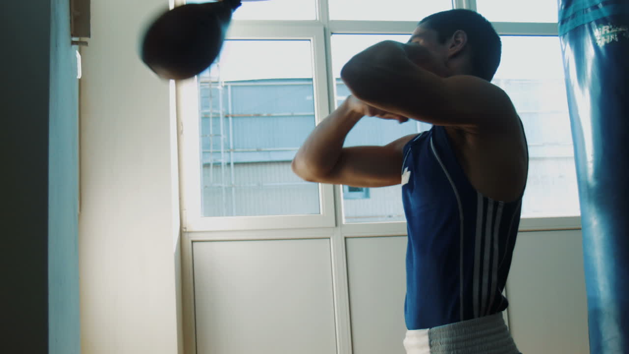 젊은 권투 선수가 권투 봉투를 가지고 훈련하고 있습니다.