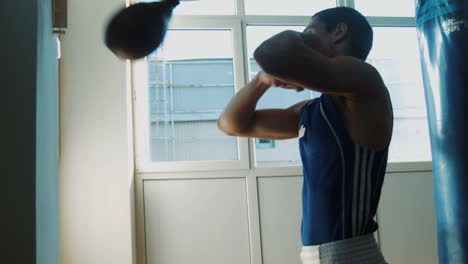 entrenamiento de boxeador joven con saco de boxeo