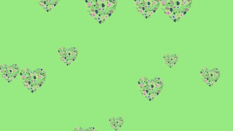 Animation-of-flower-filled-heart-shapes-floating-over-light-green-background