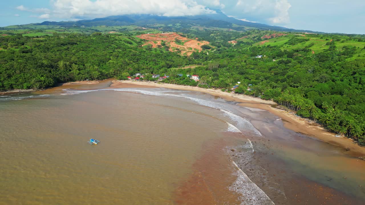 Raised aerial of Quinawan Beach in Mariveles, Bataan, capturing sandy shoreline, brown waters, and lush green hills framing the coastal village and palm‑lined edge
