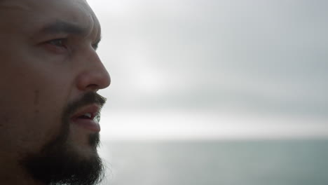 retrato de un deportista tranquilo mirando a la distancia meditando al aire libre en un día nublado.