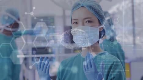 animation of medical data processing over portrait of asian female surgeon in operating theatre