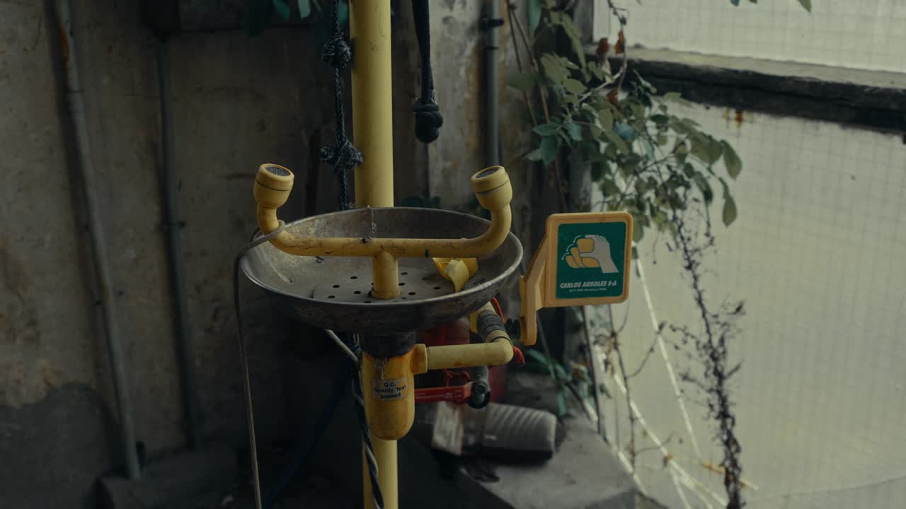Old Rusty Yellow Eye Wash Station in Abandoned Industrial Setting