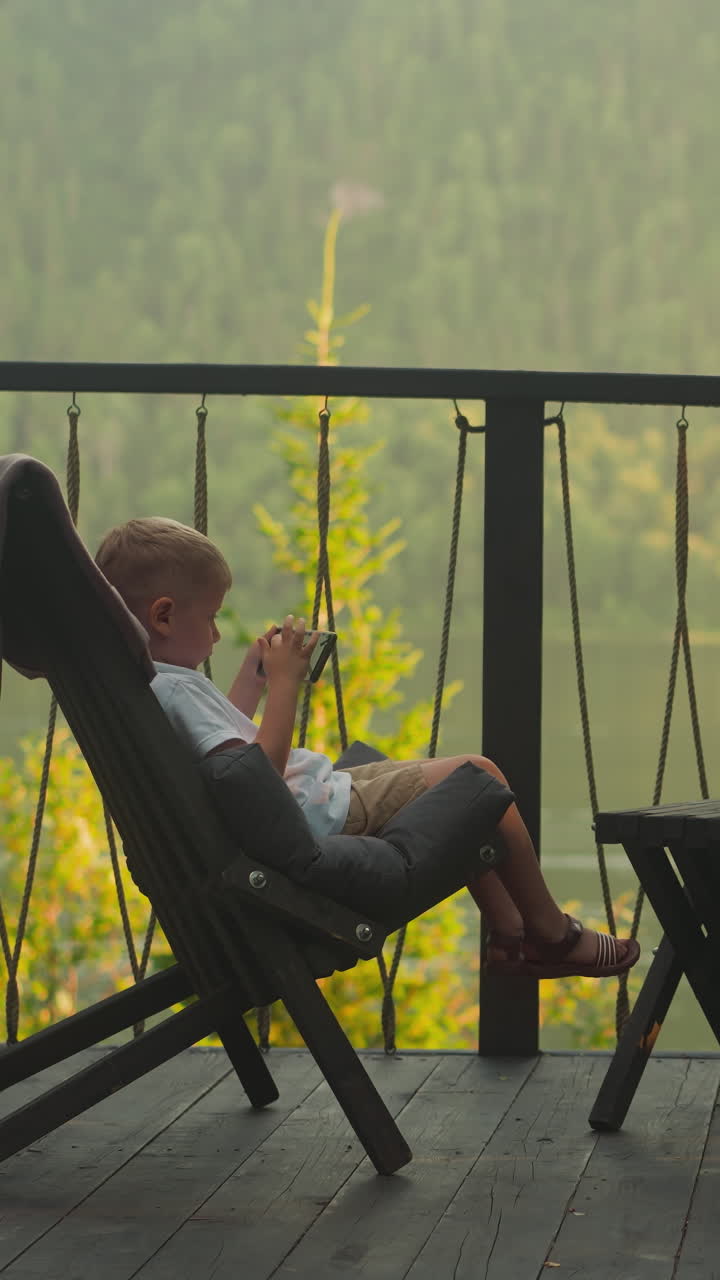 la niña y el niño se sientan juntos en sillones de pelo en la terraza al aire libre. los niños descansan disfrutando de una escena de naturaleza tranquila. una escena fantástica de bosque intacto