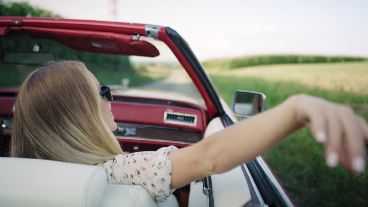 video de mano de una mujer agitando la mano fuera del coche