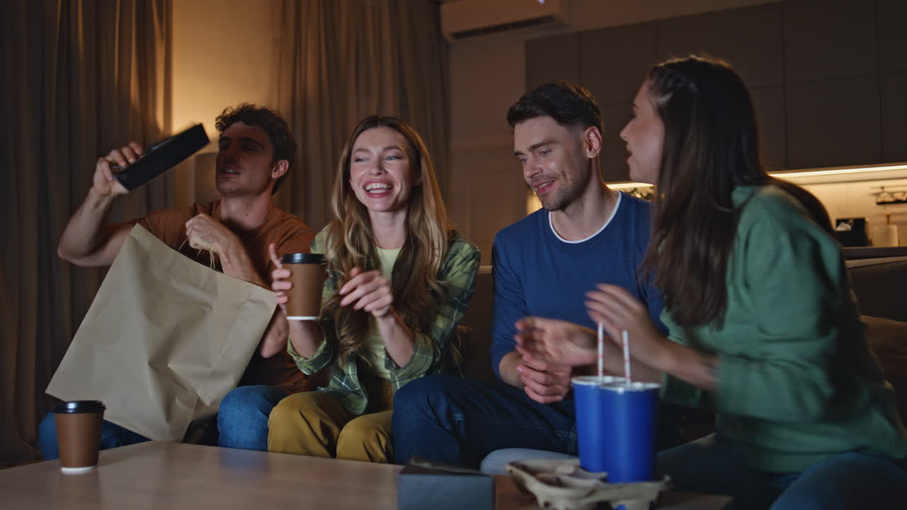 Group millennials chilling home unpacking food delivery on evening gathering.