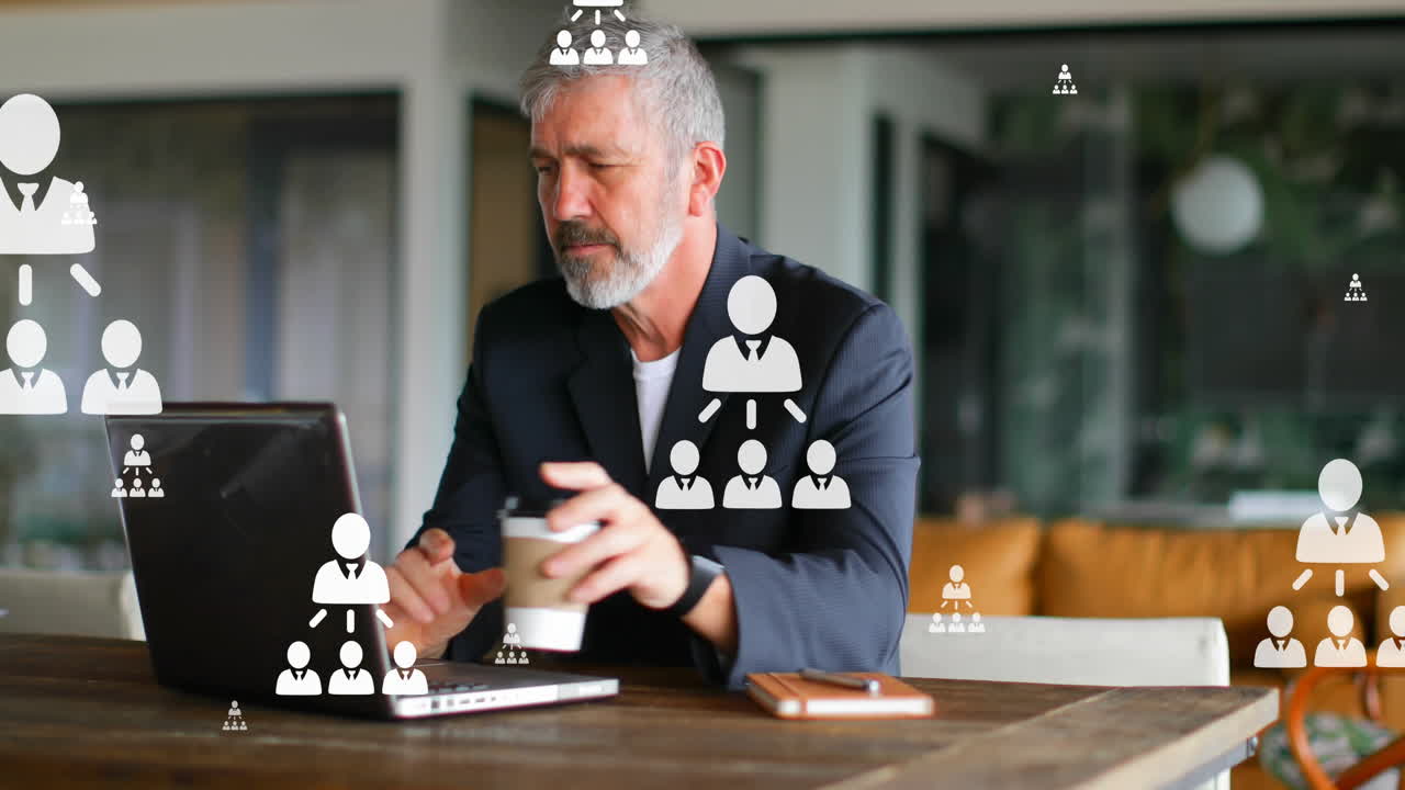 Animation of flowcharts over caucasian man drinking coffee while working on laptop