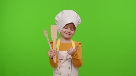 niña cocinera chef panadero en delantal y sombrero sonriendo, asintiendo con la cabeza en acuerdo con el fondo de la llave de croma