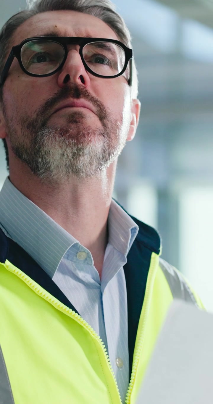 Professional Engineer Reviewing Technical Documents in Safety Vest