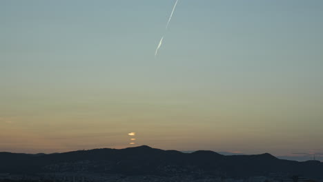 Time-Lapse-of-golden-sun-rise-over-the-majestic-mountain-ridge-near-the-picturesque-coastal-city