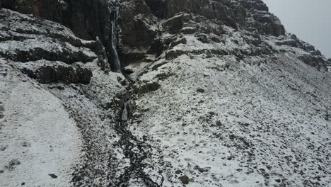 aerial-view,-drone-shot-of-a-waterfall-on-a-snowy-mountain-in-South-Iceland,-near-Vatnajökull-national-park