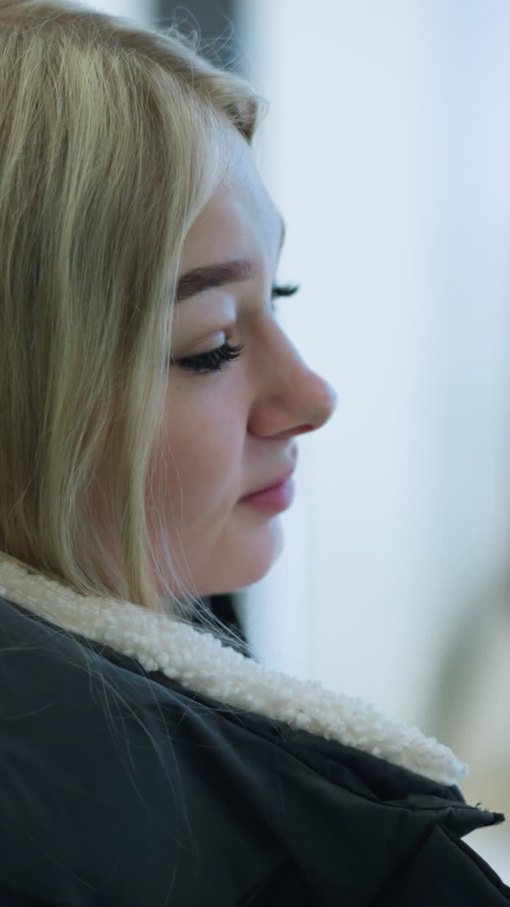 primer plano de una mujer de carrera mirando a su derecha mientras está en una escalera mecánica en movimiento en un centro comercial, la luz parpadeando en el fondo borroso agrega un toque moderno a esta escena urbana
