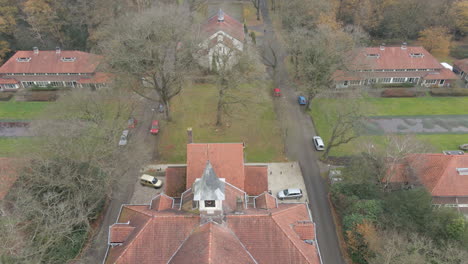 Jib-down-of-clocktower-on-old-building-overseeing-beautiful-village-in-autumn