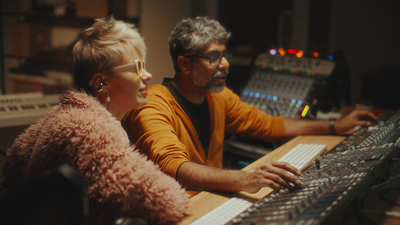 Sound Engineer and Female Musician Collaborating in Recording Studio