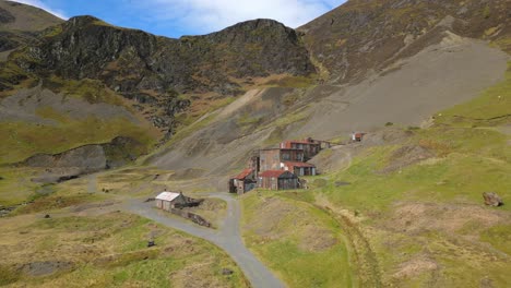 excursionistas caminando hacia viejos edificios abandonados en la mina force crag coledale beck en el distrito de los lagos ingleses