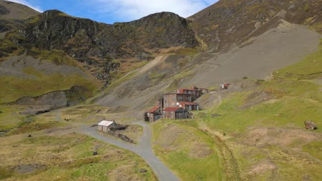 hikers walking towards old abandoned buildings at force crag mine coledale beck in the english lake district