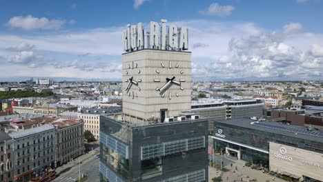 Cinematic-aerial-footage-of-the-Riga-train-station-clock-tower-in-Latvia,-Europe-standing-still-and-clouds-moving-in-the-background