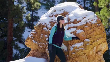 girl womanstanding with red rocks formation and snow near bryce canyon in southern utah