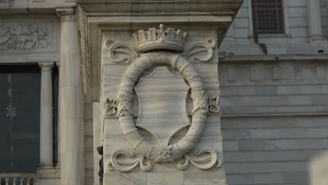 detailed marble carving with crown and crest on a historic building