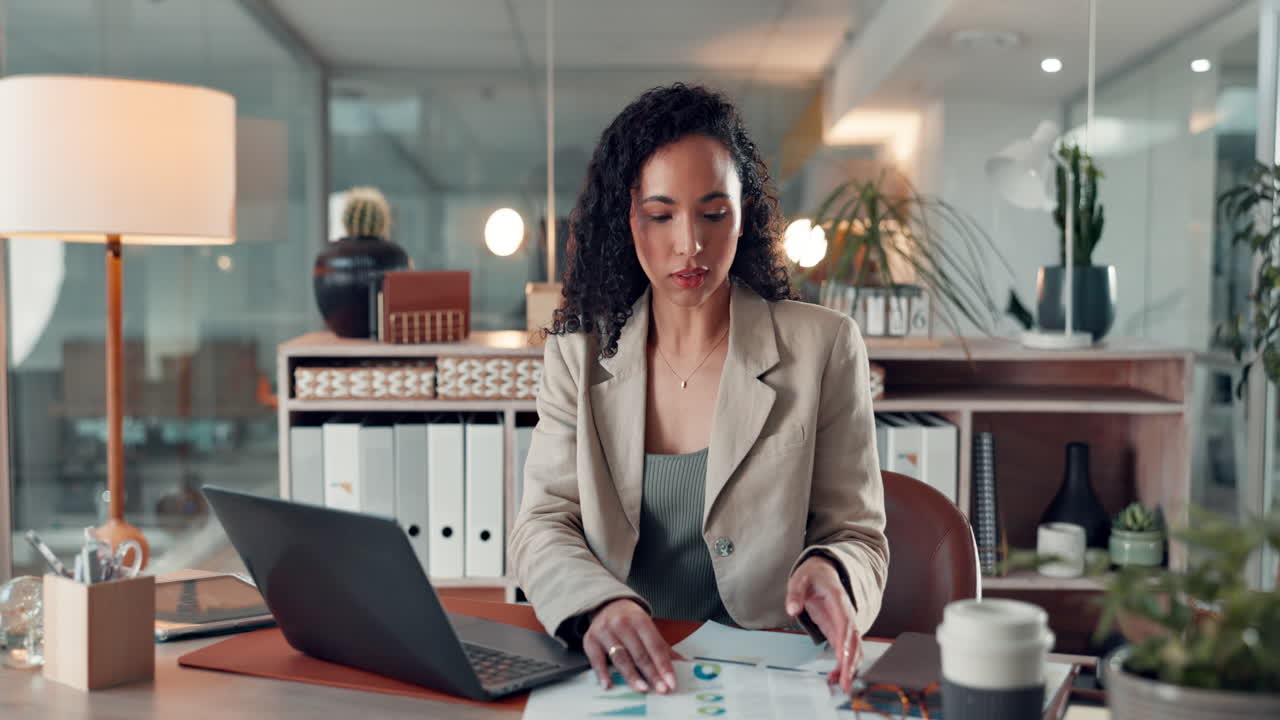 Businesswoman working in her office with laptop and documents