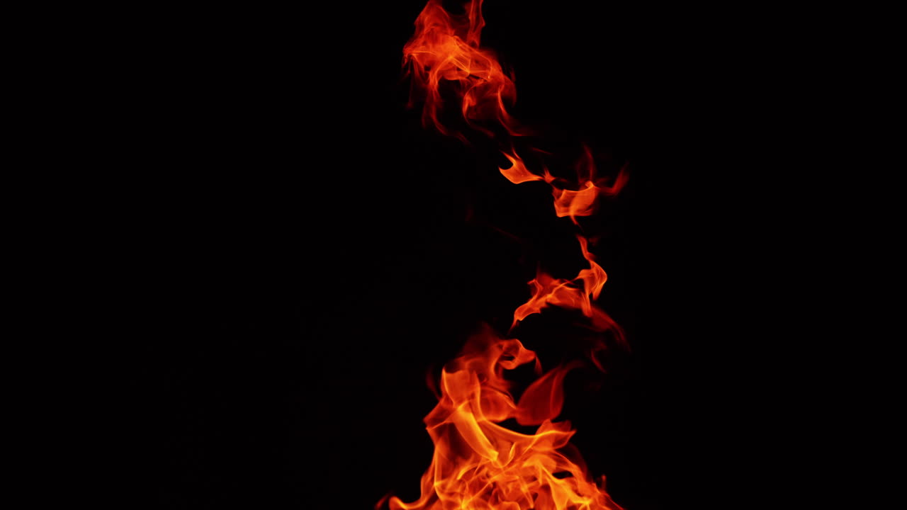 Upper part of bonfire burning at night. Flame tongues reach into the air. Close up.