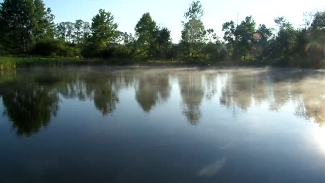 Quiet-misty-lake-in-the-morning,-water-surface-angle-of-a-scenic-lake-with-no-people,-still-shot