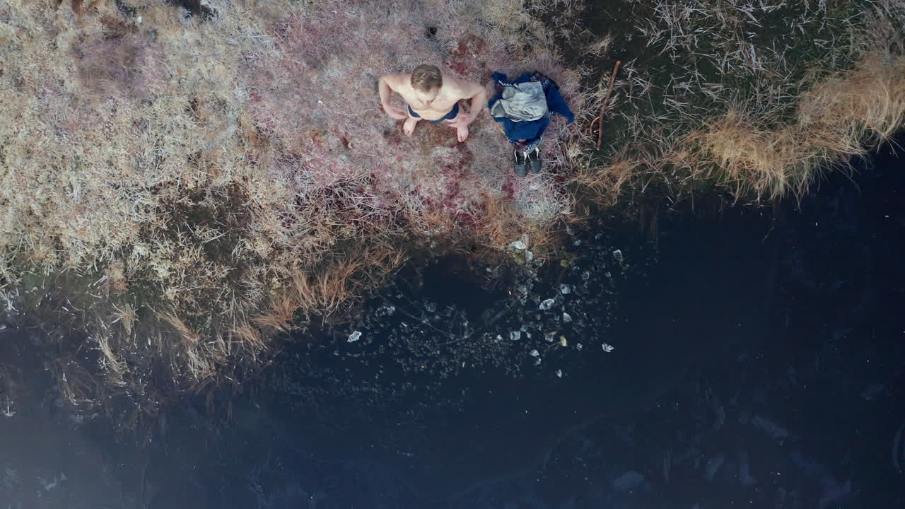 AERIAL TOP DOWN - An ice bather does some qigong after being in the lake