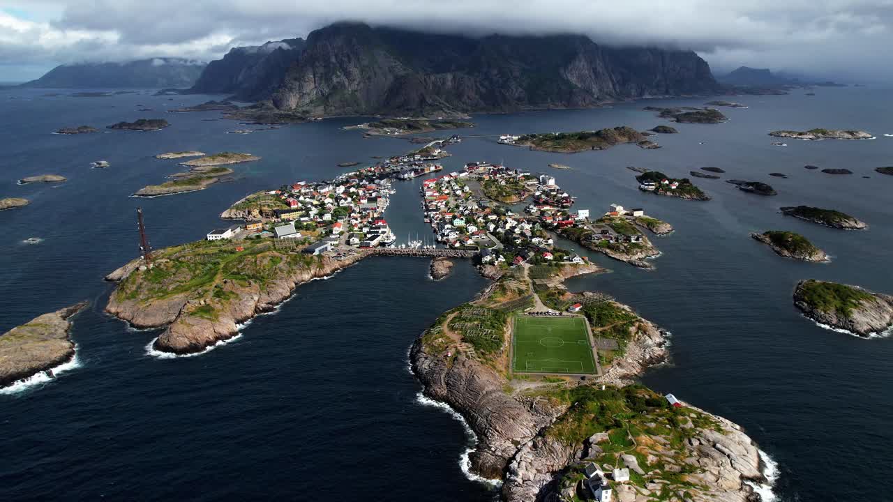 노르웨이 로포텐 의 아름다운 축구장 과 헤닝스바어 시 와 그 뒤 에 있는 노르웨이 로포텐 의 산 들 의 영상