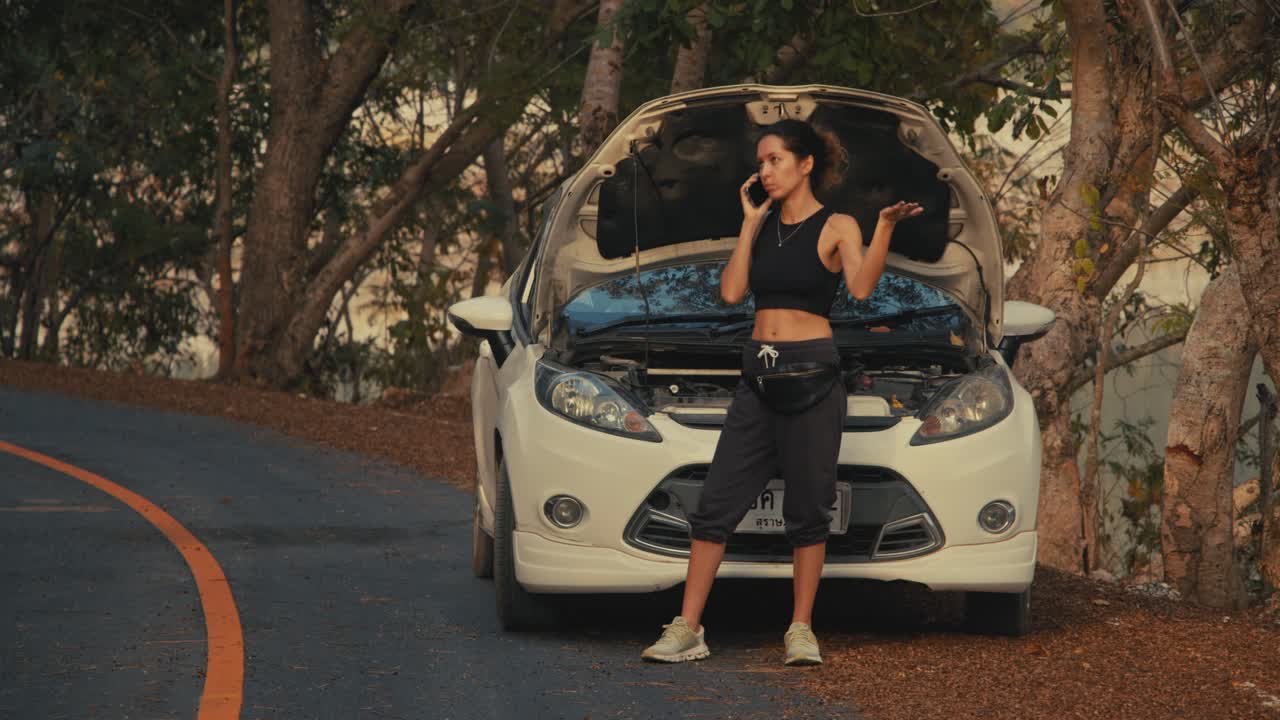 Woman on the side of the road with a broken down car
