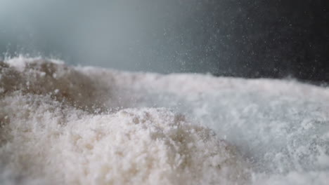 powdered sugar bounces on surfaces from vibration of table