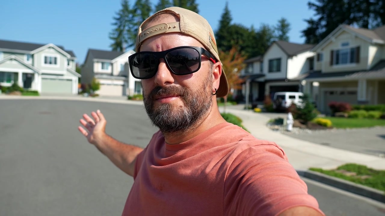 Uomo che registra un video selfie in un quartiere residenziale