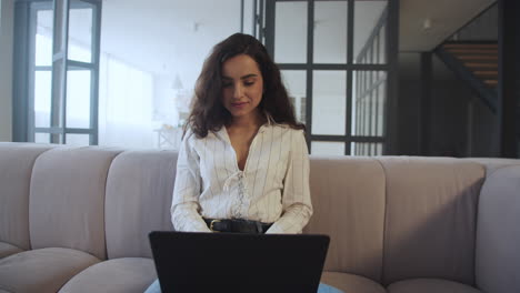 mujer de negocios escribiendo en una computadora portátil en casa
