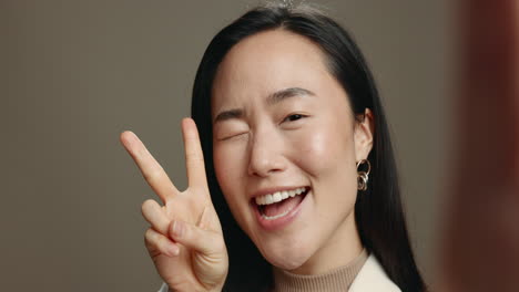 asian, heart and selfie of woman with peace symbol