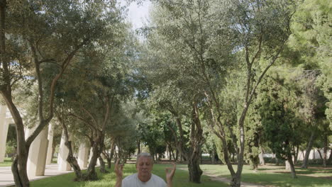 elderly man practicing yoga in the park