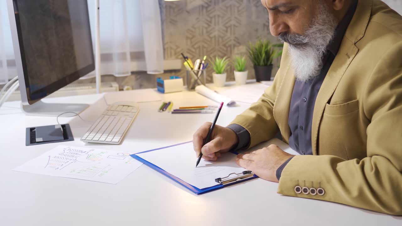 hombre de negocios dibujando y analizando un gráfico en una hoja de papel.