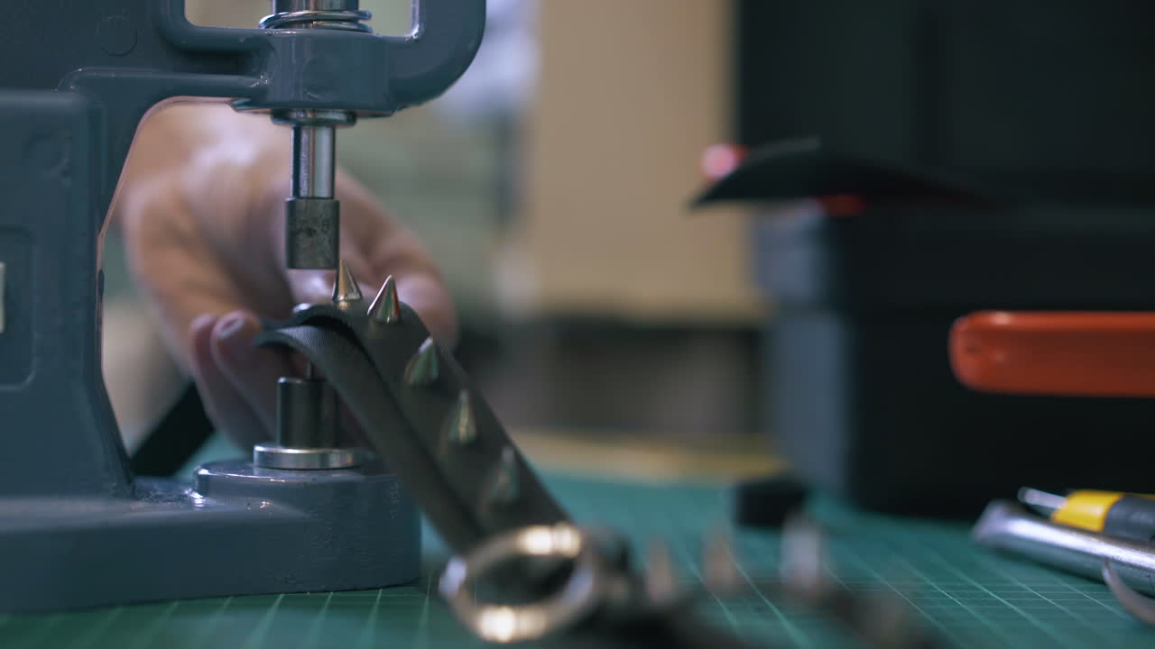 el sastre experto pone accesorios en un cuello de cuero negro.