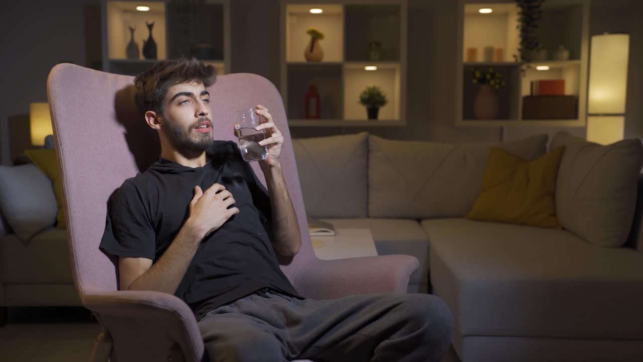 el hombre cobarde bebe agua con la mano temblorosa.