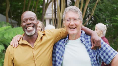 animation of happy diverse male senior friends embracing in garden