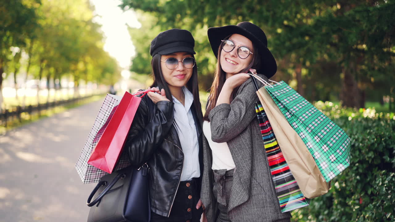 Two happy women shopping outdoors