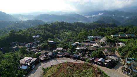 southeast asian village sits off mountain road bend with epic views of cloudy valleys