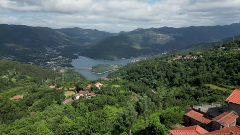 Vista-Aérea-De-Casas-En-El-Parque-Nacional-De-Gerês,-Portugal,-Con-Vistas-A-La-Presa-De-Caniçada-En-Un-Día-Despejado,-Parque-Nacional-Peneda-Gerês