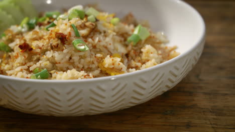 Plated-crab-fried-rice-topped-with-chopped-green-onions,-slider-close-up-4K