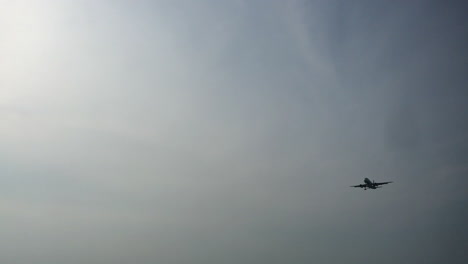 an airplane flies over a marina full of boats in thailand