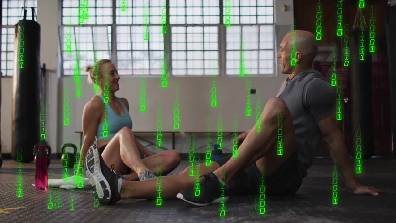 Fitnesspartnere sidder i fitnesscenter og ser grøn binær streaming, giver derefter high-five for motivation