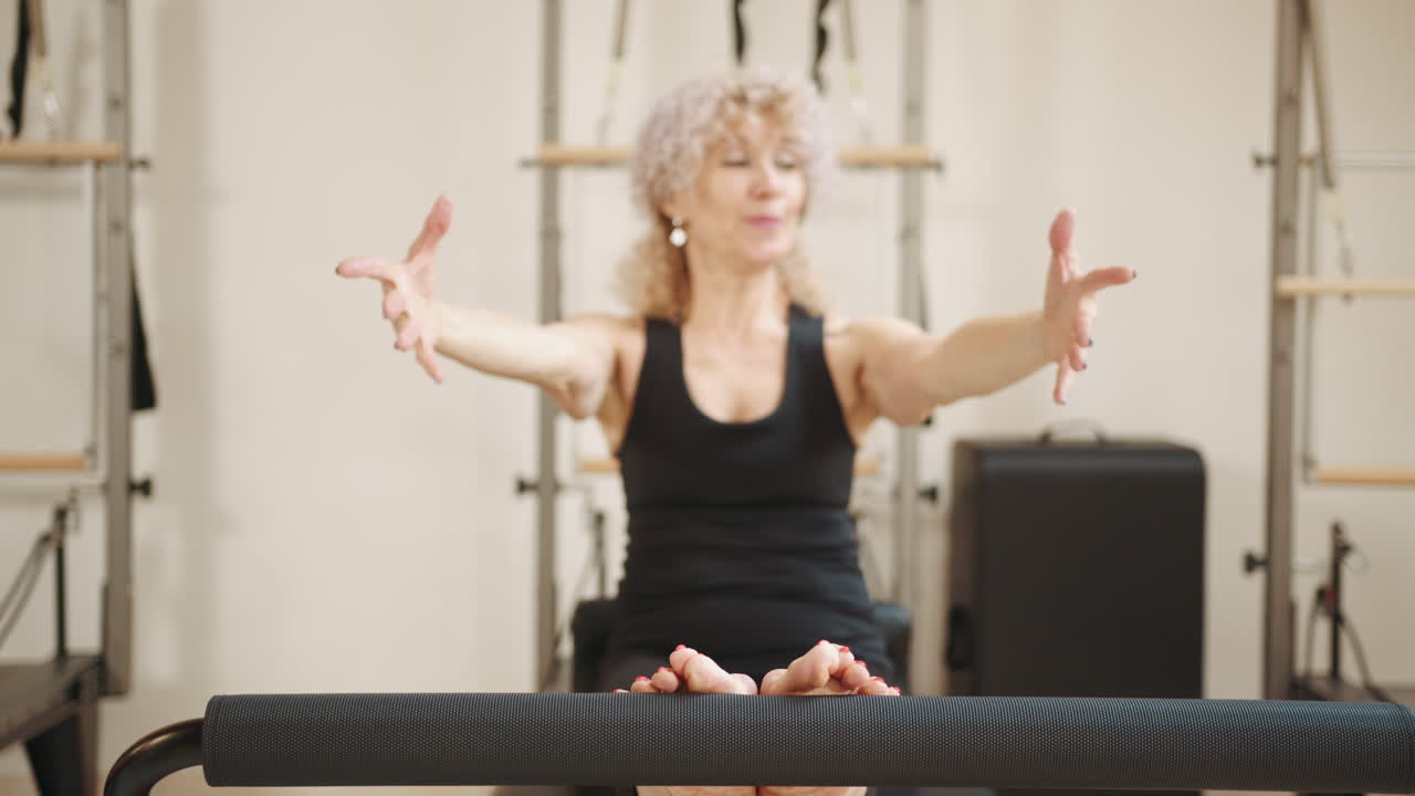 mujer mayor haciendo pilates en reformador