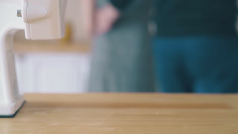 girl with flour and man with domestic grinder on foreground