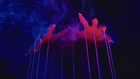 puppet master hands in neon smoke